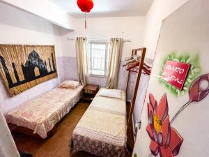 um quarto com duas camas e uma placa na parede em Toca da Mona Roots Hostel em Vitória