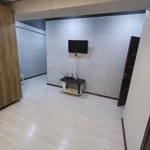 キシナウにあるApartamentの壁にテーブルとテレビが備わる部屋