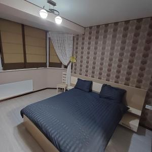 1 dormitorio con 1 cama grande con almohadas azules en Apartament, en Chişinău