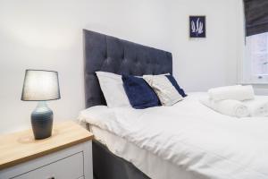 a bedroom with a large bed with a blue headboard at Stylish 1 Bedroom Apartment in Central London in London