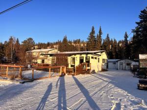 a house in the middle of a snow covered yard at Whitehorse Home on the River in Whitehorse