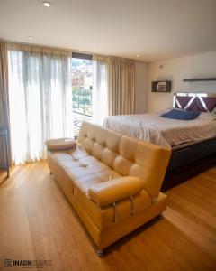 a bedroom with a large bed and a leather couch at Bed and Breakfast Hotel Cruzmorph in Bogotá