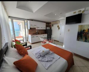 a bedroom with a large bed and a kitchen at Hotel Arco Iris in Atacames
