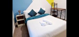 a bedroom with a white bed with blue walls at Gillingham Home - Sleeps 4 - Comfort & Convenience in Gillingham