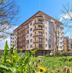 a large apartment building in front of a field of flowers at Apartment Studio Shevitsa 2 in Veliko Tŭrnovo