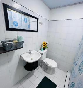 een witte badkamer met een toilet en een wastafel bij Casa Cabieles Hostal in Yopal