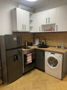 a kitchen with a refrigerator and a washing machine at Apartment Studio Shevitsa 2 in Veliko Tŭrnovo