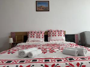 a bed with red and white blankets and pillows at Apartment Studio Shevitsa 2 in Veliko Tŭrnovo