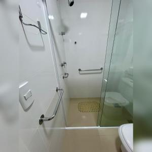 um chuveiro com uma porta de vidro na casa de banho em Fique pertinho do mar em Itapema