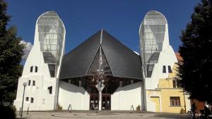 a large white building with two glass towers at Central Apartman Makó in Makó