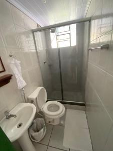 a bathroom with a shower and a toilet and a sink at Pousada Meu Cantinho in Conservatória