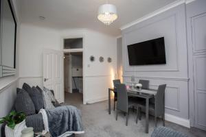 een woonkamer met een bank, een tafel en een televisie bij The Brighton in Gateshead