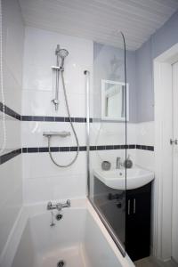 een badkamer met een bad en een wastafel bij The Brighton in Gateshead
