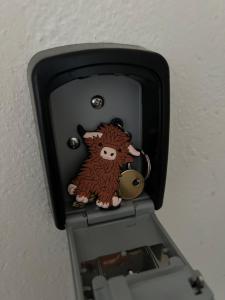 a small toy cow on top of a lightswitch at The Heilan' Coo Apartment in Helensburgh