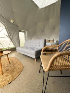 een woonkamer met een bank en stoelen in een tent bij NaturHotel in Cuenca