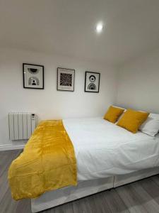 a bedroom with a bed with a yellow blanket on it at Your Home-Big offers for Groups! in Leeds