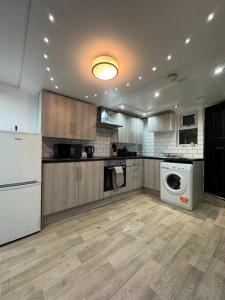 a kitchen with a refrigerator and a washer and dryer at Your Home-Big offers for Groups! in Leeds