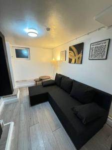 a living room with a black couch in a room at Your Home-Big offers for Groups! in Leeds