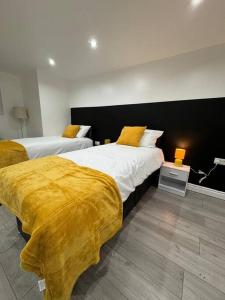 a bedroom with two beds with yellow blankets at Your Home-Big offers for Groups! in Leeds