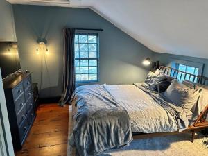 um quarto com uma cama e uma janela em The Saltbox Greenport em Greenport