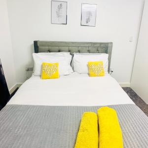 a bedroom with a bed with yellow pillows at Private Modern Ensuite Room near Etihad Stadium in Manchester