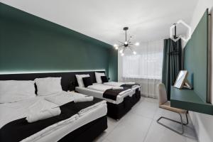 Day Young Life Apartment / DYL_Hosting في نورنبرغ: غرفة نوم بثلاث اسرة وجدار اخضر