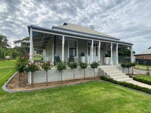 a house with a porch with potted plants on it at The Cottage at Seppeltsfield, Barossa Valley in Seppeltsfield