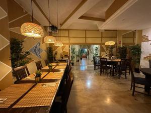 un ristorante con tavoli lunghi, sedie e luci di Casa Alondras ad Arona