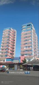 twee grote hoge gebouwen op een strand met bij Hotel Arco Iris in Atacames