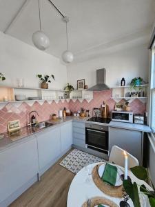 uma cozinha com armários brancos e uma mesa com uma vela em Beautiful and spacious flat em Londres