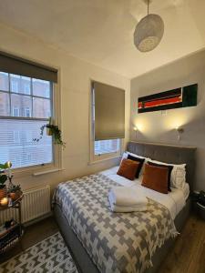 a bedroom with a bed and two windows at Beautiful and spacious flat in London