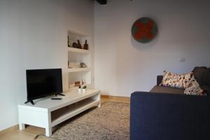 ein Wohnzimmer mit einem TV und einem Sofa in der Unterkunft Casa Nonna Delfina in Tortolì