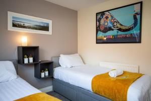 a bedroom with two beds and a picture on the wall at Stylish Cosy Two Bed Apartment - Coast Location in Whitley Bay