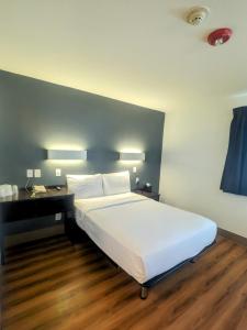 1 dormitorio con 1 cama blanca grande y escritorio en Econo Lodge en Idaho Falls