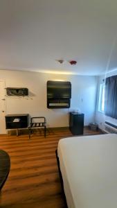 Econo Lodge في ايداهو فولز: غرفة نوم بسرير ابيض وارضية خشبية