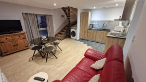uma sala de estar com um sofá vermelho e uma cozinha em jolie petite maison 134 lugan em Lugan