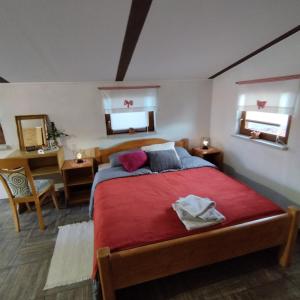 een slaapkamer met een bed met een rode deken en 2 ramen bij Holiday home Novak M in Sveti Martin na Muri