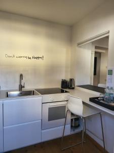 eine weiße Küche mit einer Spüle und einer Theke in der Unterkunft La Casa dei Turchi in Rovereto