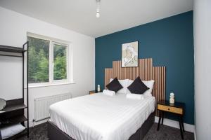 a bedroom with a large bed with a blue wall at The Burnopfield in Burnopfield