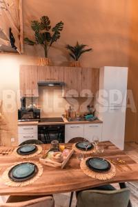 a kitchen with a wooden table with plates on it at Spa nature in Vimy