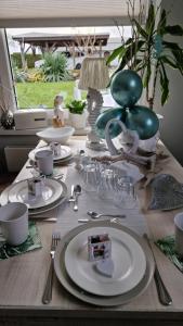 a wooden table with plates and dishes on it at Apartment Mai in Elmenhorst