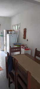 a kitchen with a dining table and a refrigerator at Chalé Barra Sirinhaém in Sirinhaém