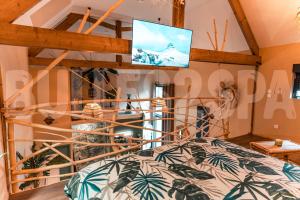 a bedroom with a bed with a tv on the wall at Spa nature in Vimy