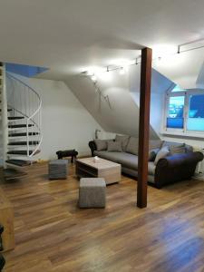uma sala de estar com um sofá e uma escada em Helle Maisonnette Wohnung Penthouse em Recklinghausen