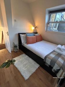 - une chambre avec un lit, une fenêtre et un tapis dans l'établissement Charming Fulham flat, à Londres