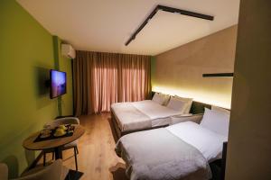 a hotel room with two beds and a table at 1863 Boutique Hotel in Peje
