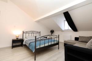ein Schlafzimmer mit einem Bett und einem Sofa in der Unterkunft Gîte spacieux propre proche Gérardmer in Granges-sur-Vologne