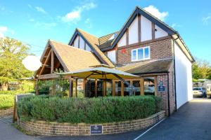 un edificio con una sombrilla delante de él en Entire Apartment in Central Brockenhurst en Brockenhurst