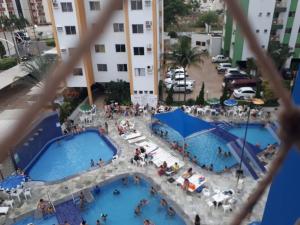 uma vista panorâmica de duas piscinas num edifício em Res Águas da Serra - 2 quartos em Caldas Novas