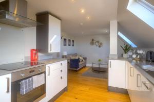 een keuken met witte kasten en een woonkamer bij Entire Apartment in Central Brockenhurst in Brockenhurst